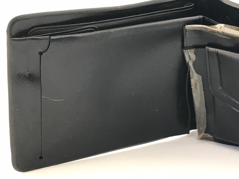 May include: A black leather wallet with multiple compartments and folds. The wallet is open and the inside is visible.