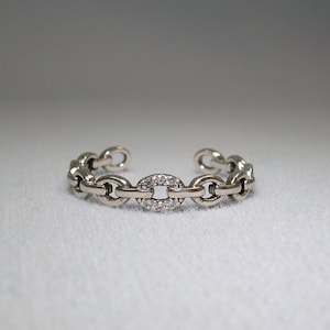 May include: A silver chain bracelet with a round, pave-set diamond accent.
