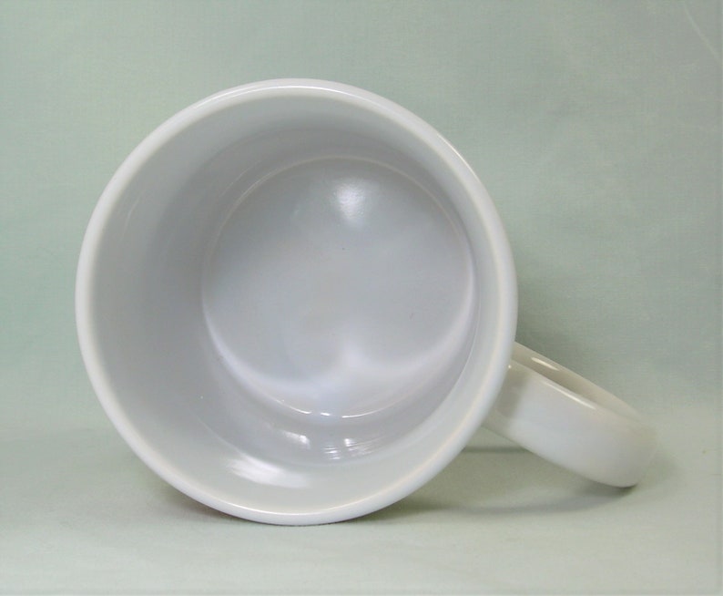 Puede incluir: Taza de cer&aacute;mica blanca con un acabado liso y brillante. La taza tiene una forma redondeada y un asa.