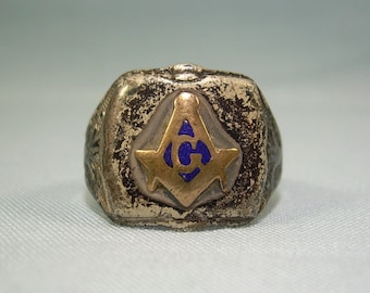 May include: A silver Masonic ring with a gold square and compass design. The compass has a blue enamel center with a letter 'G' inside.