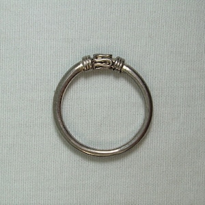 Peut inclure: Une bague en argent avec un motif décoratif sur la bande.