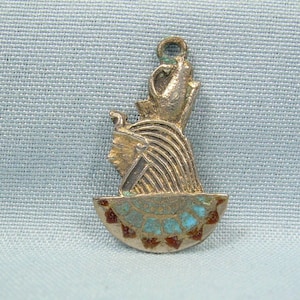 Op de afbeelding: Zilveren hanger met een gedetailleerd profiel van een Egyptische godin met een kroon van turquoise en rood email.