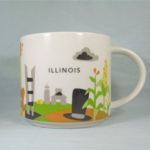 May include: White ceramic coffee mug featuring a colourful illustration of the Chicago skyline and the text "ILLINOIS".