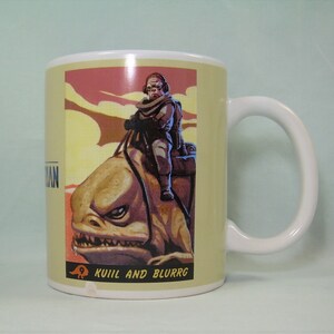 Puede incluir: Una taza de cer&aacute;mica blanca con asa. La taza presenta una ilustraci&oacute;n colorida de un personaje montando una criatura con el texto "Kuill and Blurrgg".