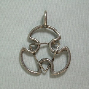 May include: A silver metal puzzle pendant with a complex, interwoven design. The pendant has a loop at the top for attaching to a chain.