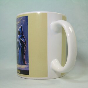 May include: White ceramic mug with a beige stripe design. The mug features a colorful illustration of a character from the Star Wars universe.