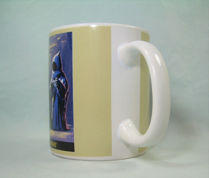 May include: White ceramic mug with a beige stripe design. The mug features a colorful illustration of a character from the Star Wars universe.