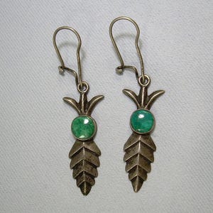 Puede incluir: Un par de pendientes de plata con piedras turquesa verdes y un diseño de hoja.