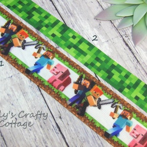 May include: Two ribbons with Minecraft-themed designs. One ribbon features pixelated characters and a pink pig on a white background, bordered by brown and green. The other ribbon has a green pixelated pattern. The text "Tally's Crafty Cottage" is visible.