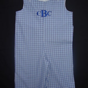 Puede incluir: Pantalón vaquero azul y blanco a cuadros con un monograma bordado en azul "CBC" en la parte delantera.