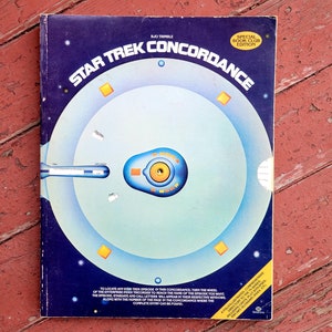 May include: A blue and yellow book cover with the title "Star Trek Concordance" and a graphic of the Starship Enterprise. The book is a special book club edition.