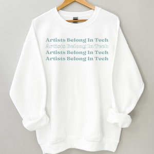 May include: White sweatshirt with the text "Artists Belong In Tech" repeated four times in a light blue color.