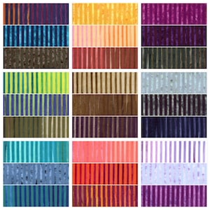 May include: A collection of fabric swatches with vertical striped patterns in various colors. The swatches include shades of blue, purple, orange, yellow, green, and brown. The stripes vary in width and color intensity, creating a visually diverse display.
