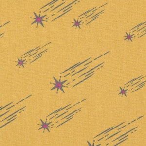May include: Mustard yellow fabric with a repeating pattern of stylized shooting stars. Each star is a deep pink color with gray streaks trailing behind it. The fabric has a textured appearance.
