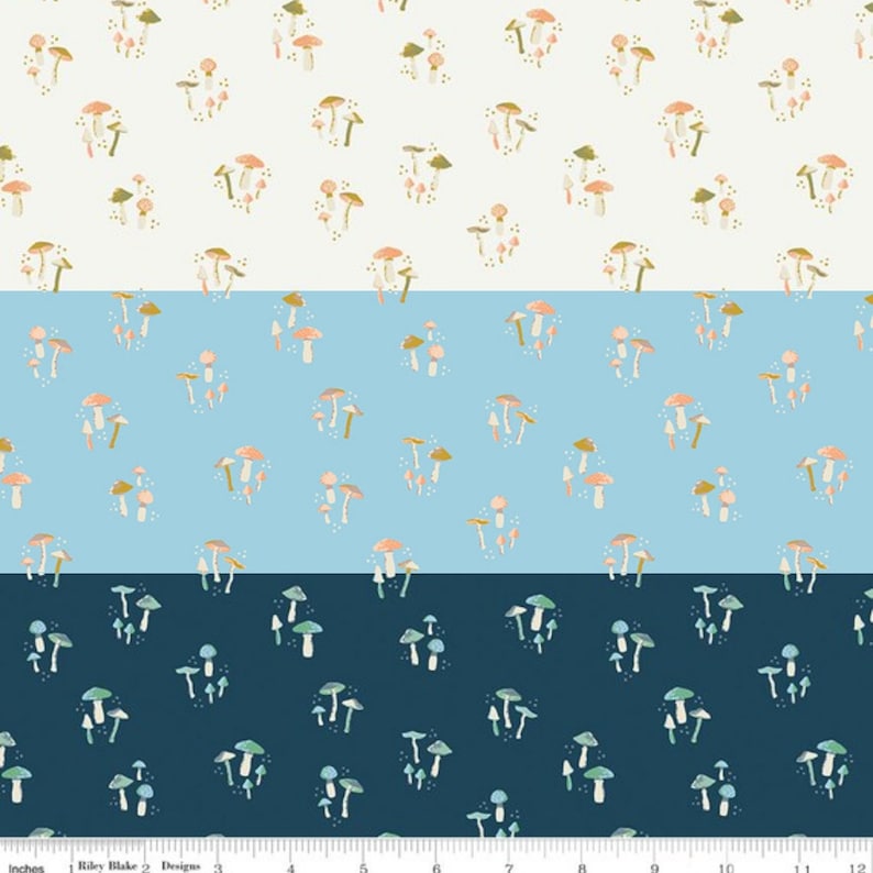 May include: A white, light blue, and dark blue fabric with a repeating pattern of colourful mushrooms. The fabric is ideal for quilting, sewing, and crafting.