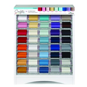 Pode incluir: Um expositor branco preenchido com 40 carretéis de linha colorida. Os carretéis estão dispostos em filas e colunas, mostrando uma ampla gama de cores, de vermelhos e laranjas vibrantes a azuis e verdes frios. A parte superior do expositor apresenta o texto "Confetti Cotton".