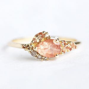 Pear oregon sunstone cluster ring with side peach sapphires and champagne diamonds, unique peach sapphire cluster ring