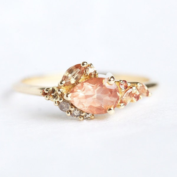 Pear oregon sunstone cluster ring with side peach sapphires and champagne diamonds, unique peach sapphire cluster ring