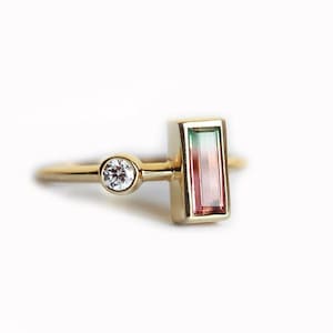 Peut inclure: Une bague en or avec un diamant rond unique et une pierre précieuse rectangulaire verte, rose et rouge.
