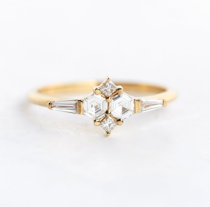 Ring with natural diamond in yellow gold. Diamond in the prong setting ring are styled as cluster ring. Shape of the diamonds are hexagonal, square and a tappered baguette.