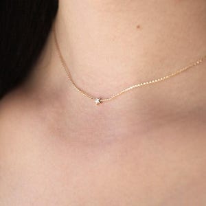 May include: A delicate gold chain necklace with a small star pendant.