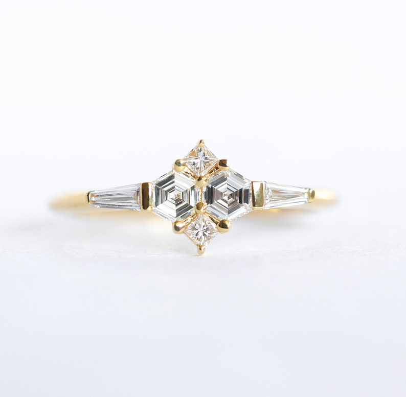 Ring with natural diamond in yellow gold. Diamond in the prong setting ring are styled as cluster ring. Shape of the diamonds are hexagonal, square and a tappered baguette.