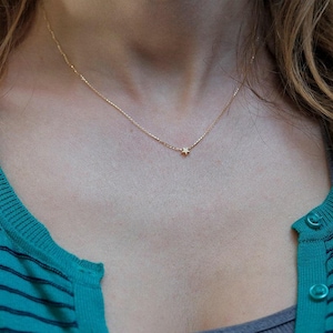 May include: A delicate gold chain necklace with a small star pendant.