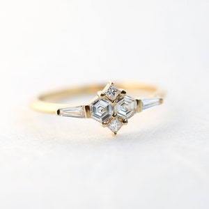Ring with natural diamond in yellow gold. Diamond in the prong setting ring are styled as cluster ring. Shape of the diamonds are hexagonal, square and a tappered baguette.