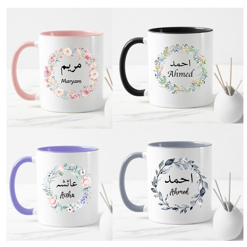 May include: Four white ceramic mugs with different colored handles and floral designs. Each mug has a name written in Arabic script and English. The names are Maryam, Ahmed, Aisha, and Ahmed.