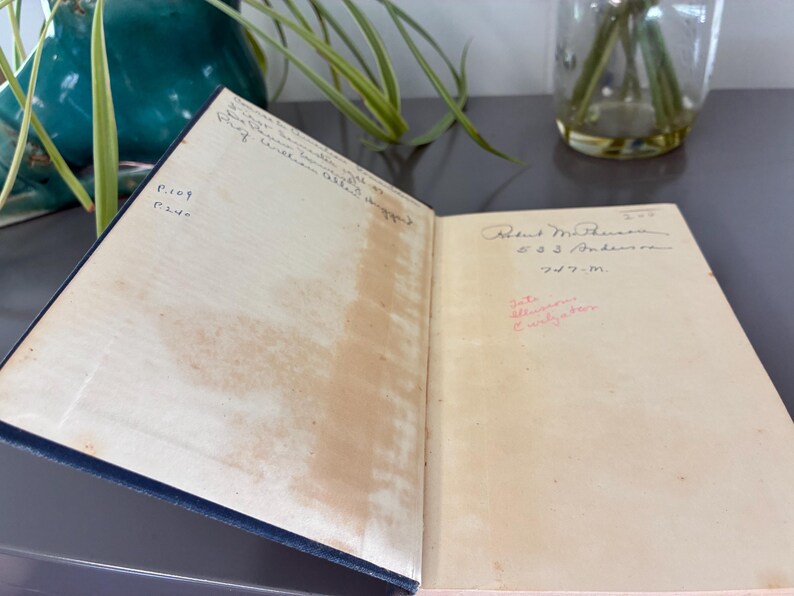 May include: An open book with aged, cream-colored pages. Handwritten text and signatures are visible on the pages. The book has a dark blue cover. The book is slightly open, revealing the interior pages.