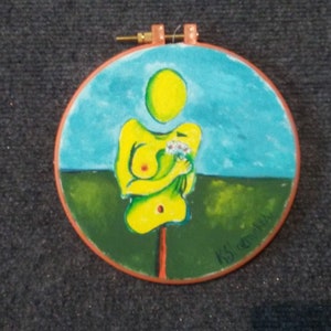 Oil painting on fabric stretched in an embroidery hoop. Strange surreal female figurewith flowers. Yellow modern art. Circular wall art