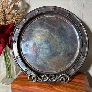 Pretty antique copper plate with 3 raised feet, rivet type edge pattern, and glossy silver-y patina. 9.25 inches. Free Shipping!
