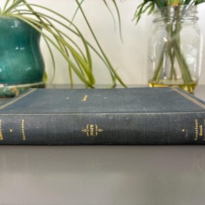May include: A vintage, hardcover book with a dark blue cover and gold lettering. The book's spine features the text "Emerson Carpenter" and the logo "AWS". The book is from the "American Book Company".