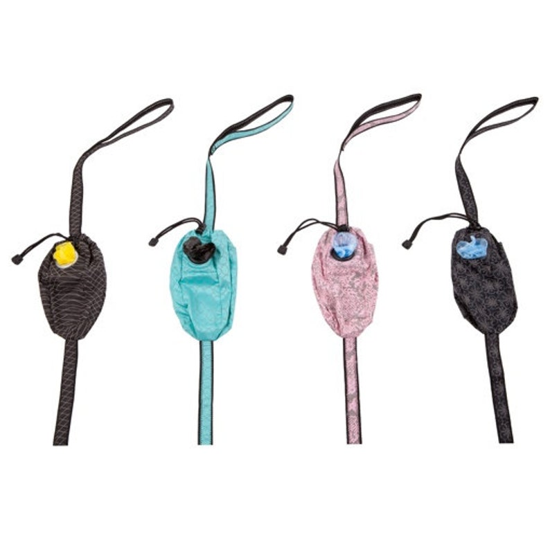 May include: Four dog waste bag dispensers with different colored patterned fabric. Each dispenser has a black strap and a small blue or yellow dispenser.