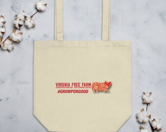 May include: A beige tote bag with a red logo that says "Virginia Free Farm" and a red pig with floral details. The logo also includes the website "virginiafreefarm.com" and the hashtag "#GrowForGood".