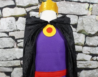 May include: A purple and black costume with a gold crown, a red belt, and a yellow circle with a red center. The costume is on a white mannequin against a stone wall background.
