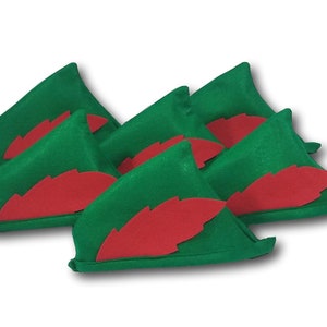 Puede incluir: Seis sombreros de elfo de fieltro verde con detalles de hoja de fieltro rojo. Los sombreros están dispuestos en fila, con las puntas de los sombreros mirando hacia adelante.
