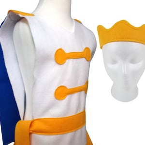 Puede incluir: Un chaleco de disfraz blanco con detalles amarillos y una faja amarilla a juego. El chaleco tiene dos botones amarillos en la parte delantera. También se incluye una diadema de corona amarilla.