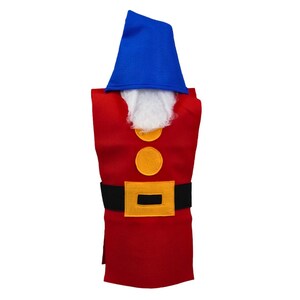 May include: A red felt bottle cover shaped like a garden gnome. It features a blue hat, white beard, two yellow buttons, and a black belt with a yellow buckle. The cover is designed to fit over a bottle.