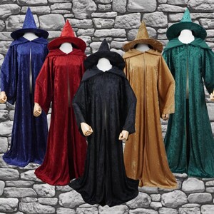 May include: Five velvet wizard robes in blue, red, black, gold, and green. Each robe has a matching pointed hat and a hooded design. The robes are displayed on mannequins against a stone wall background.