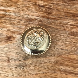 Vintage gold metal button with anchor design. Nautical