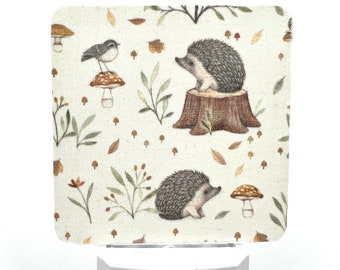 May include: A white night light with a square, cream-colored fabric cover featuring a woodland scene with hedgehogs, mushrooms, and birds. The fabric has a subtle linen texture.