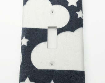 May include: A dark gray light switch cover with a white cloud and star pattern.