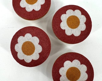 May include: Four round red fabric drawer knobs with white daisy designs and yellow centers.