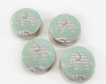 May include: Four round fabric buttons with a light green background and a white and gray elephant pattern.