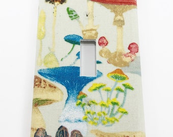 May include: A light switch cover with a colorful mushroom pattern. The cover features a variety of mushrooms in shades of red, blue, yellow, and brown.
