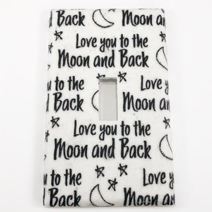 Puede incluir: Tapa de interruptor de luz blanca con un patrón blanco y negro de estrellas, lunas y el texto "Love you to the Moon and Back".