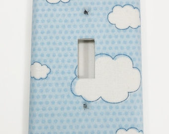 May include: Light blue light switch cover with a white polka dot pattern and white clouds with blue outlines.