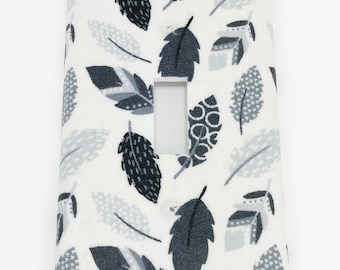 May include: White light switch cover with a black and gray feather pattern.