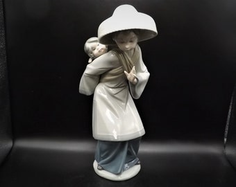 Vintage Lladro "My Precious Bundle" #5123 no box. Asian woman with Baby. Great condition - The Babies hand has been repaired as shown.